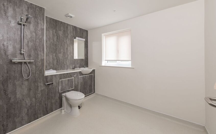 Wet room with concrete-effect panels and Altro safety flooring in a converted bathroom