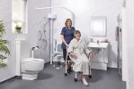 Carer assisting elderly lady in luxury accessible wet room with smart toilet and body dryer