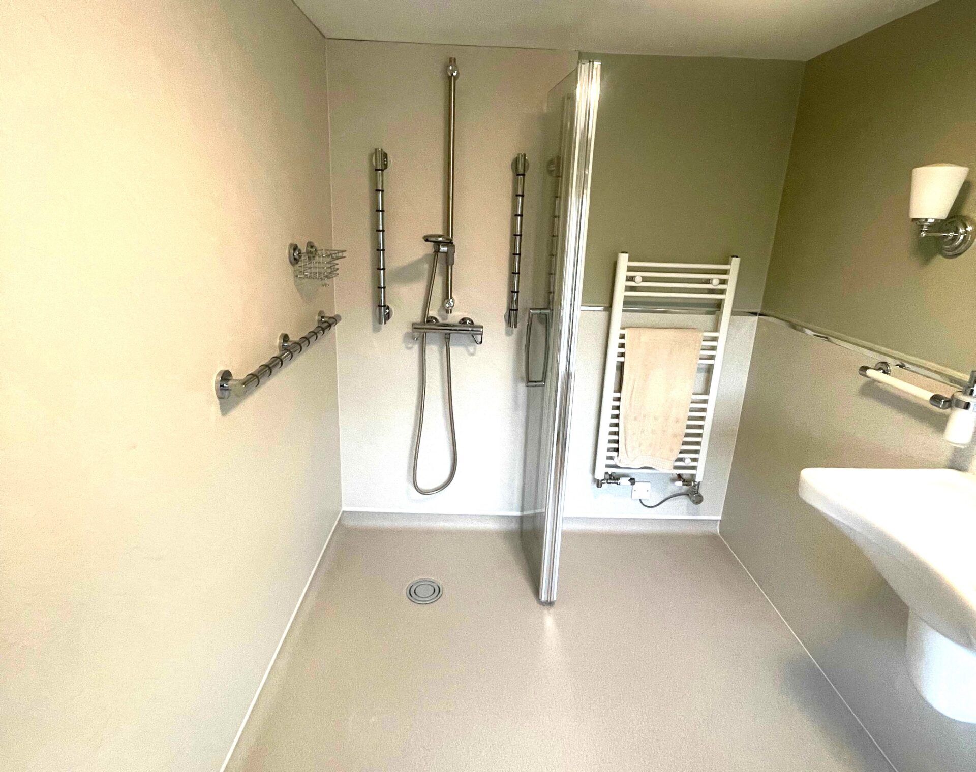 Andrew’s completed level-access wet room with Gripo support pole and consistent-height rails