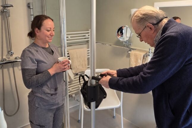 Andrew using his new wet room with support from an EA Mobility specialist